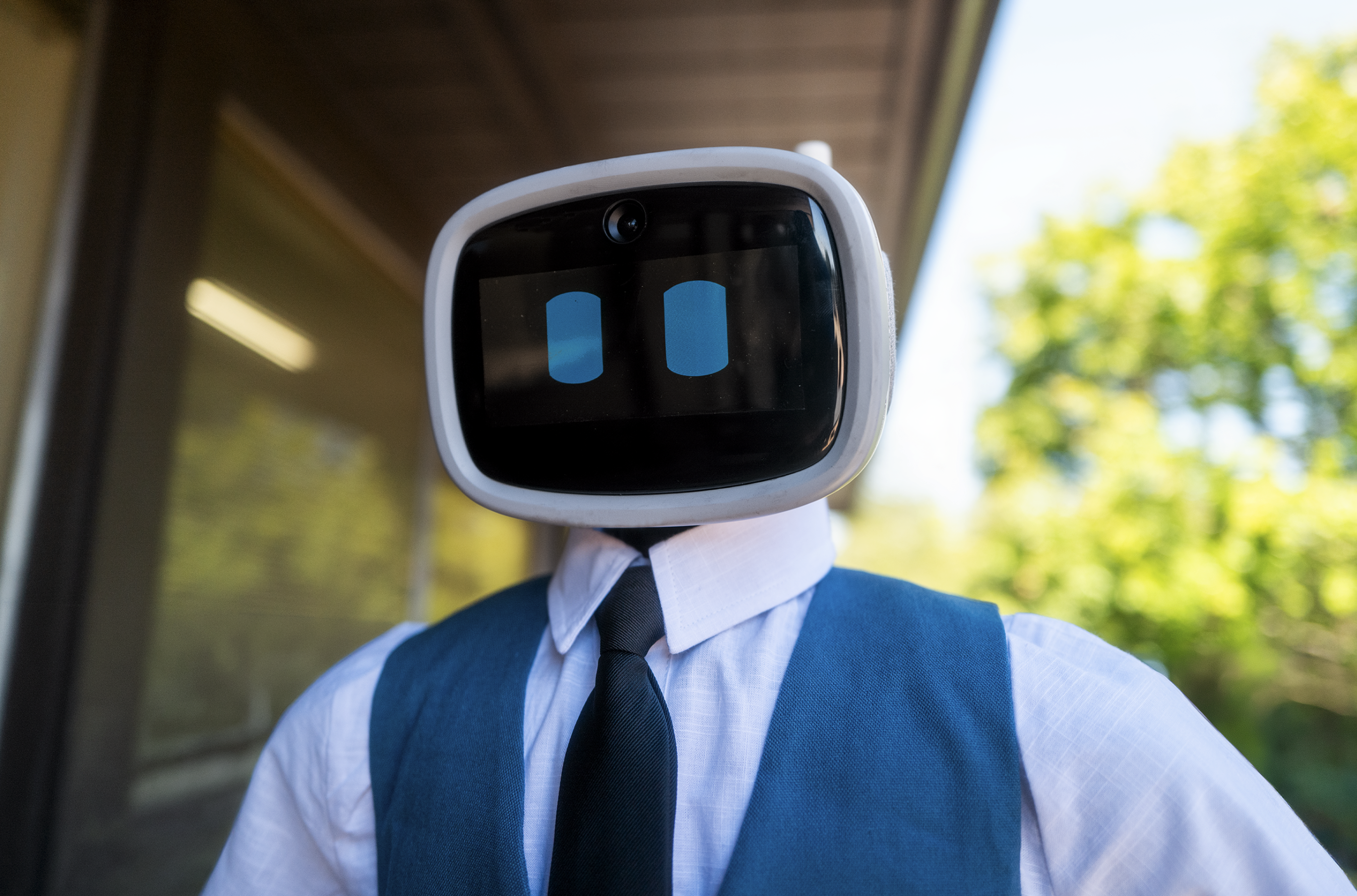 Kai, an IntBot humanoid in a vest and tie, ready to answer questions